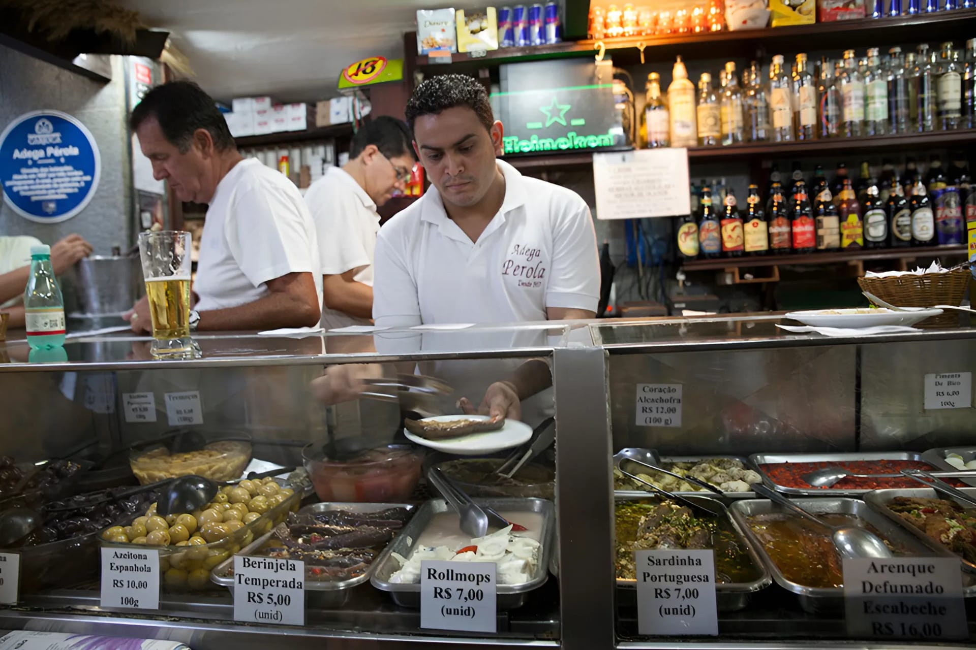man at a glass food counter