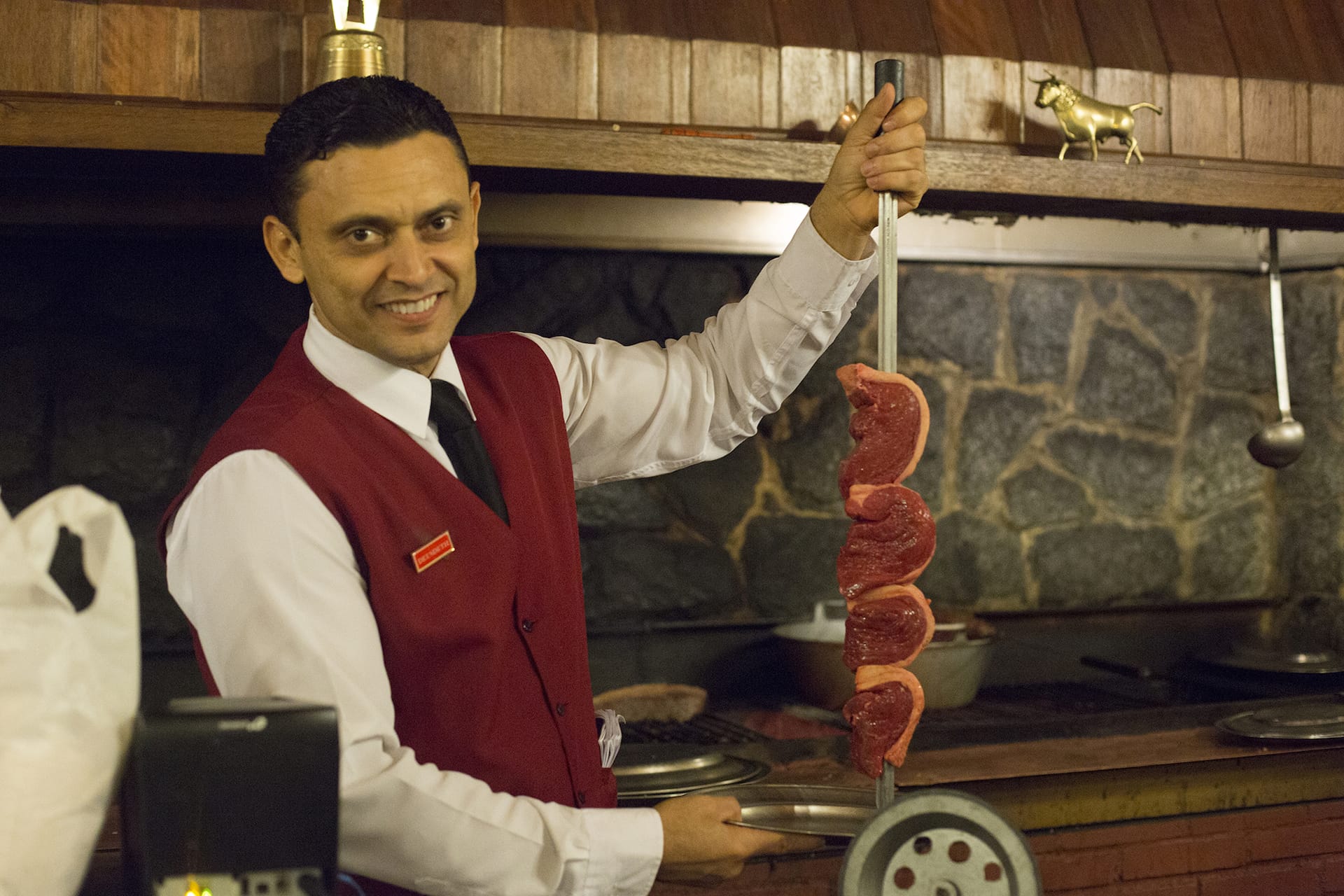 man holding skewer of steaks