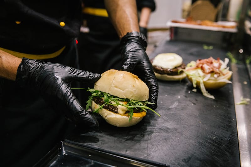 NAPLES, ITALY - 30 MAY 2019: The "'E Zizze" burger is prepared here at D'Ausilio, a butcher shop in Naples, Italy, on May 30th 2019.<br /> Raffaele D’Ausilio comes from a family of butchers. His grandfather, Alfredo d’Ausilio, opened a butcher shop in 1947. All four of his children became butchers, including Raffaele’s father Vincenzo. In the early 2000s, Raffaele and his wife Roberta took over the family business with their touch of innovation: a butcher shop during the day, a take-away burger shop at night.