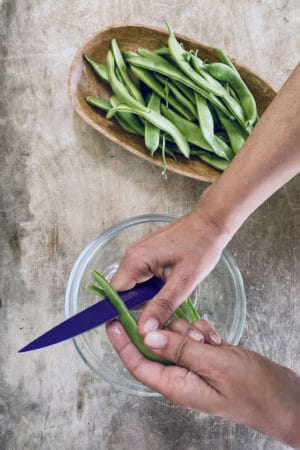 Cutting flat green beans in half lengthwise, photo by Carolina Doriti