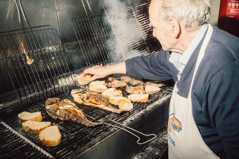 Manolis, the taverna’s namesake, works the grill, photo by Marco Arguello
