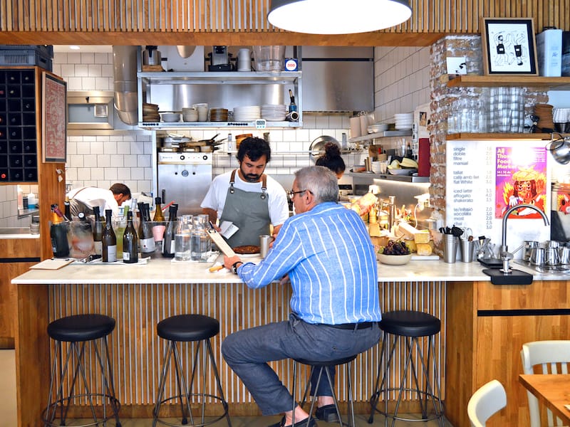A marble table separates Berbena’s kitchen from the small rectangular dining room, photo by Paula Mourenza