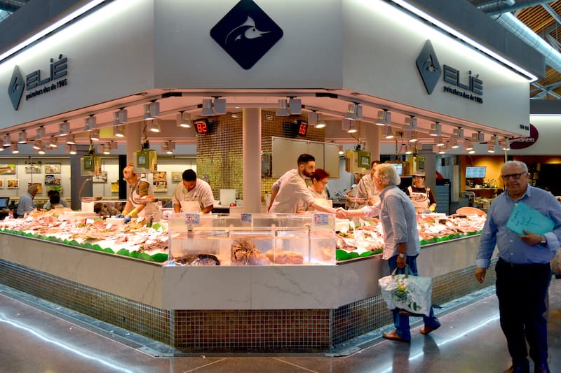 One of the fishmongers at Mercat de Sant Antoni greets a customer, photo by Paula Mourenza