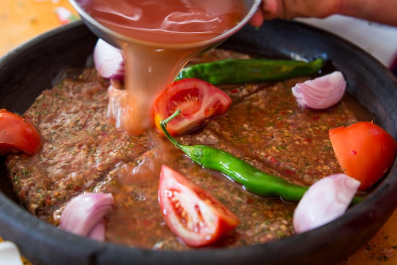 Preparing tepsi kebab to go into the wood-fired oven, photo by David Hagerman