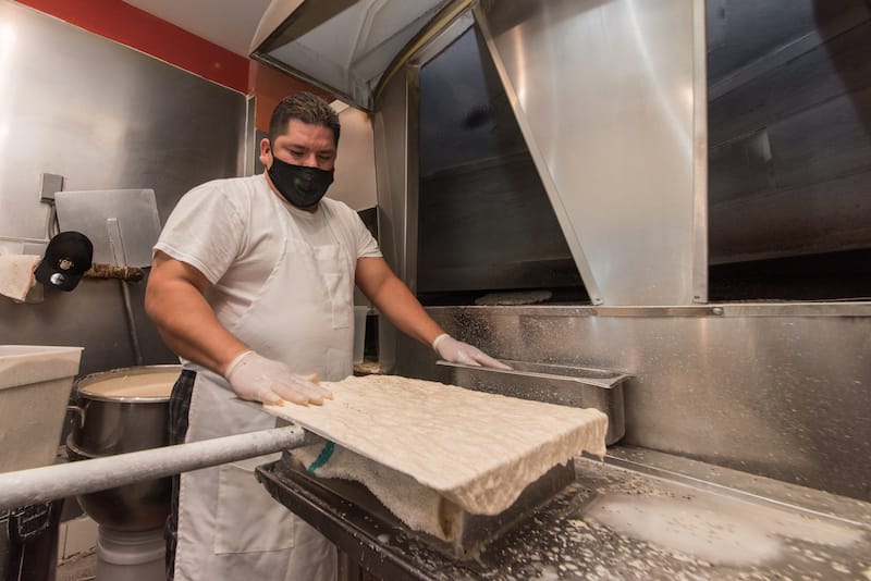 When the dough is ready, Jesus plunks a solid splatter of this wholesome slurry onto a metal plate, forcing the dough to run off its sides, photo by Vitaly Belousov