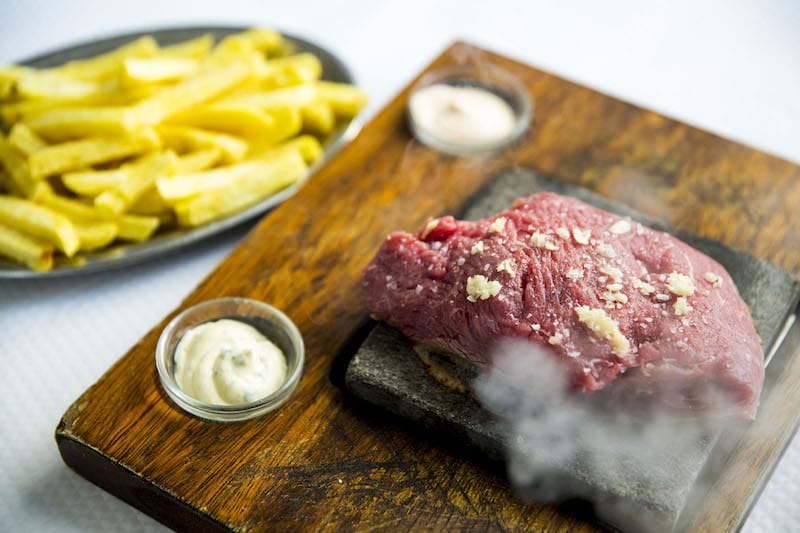 Steak on a sizzling-hot stone at Casa dos Passarinhos, photo by Rodrigo Cabrita