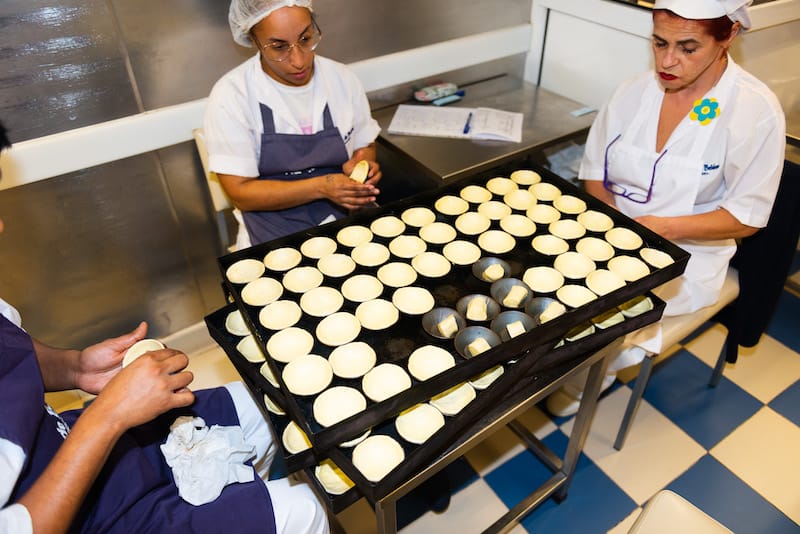 Employees press rolls of laminated pastry into cups, Pastéis de Belém, photo by Austin Bush