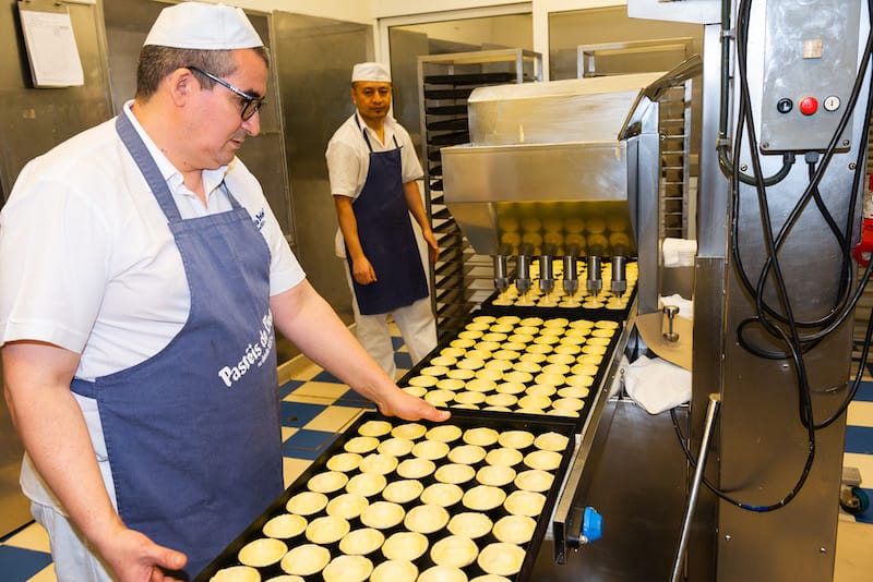 A machine injects custard into pastry cups, Pastéis de Belém, Pastéis de Belém, photo by Austin Bush