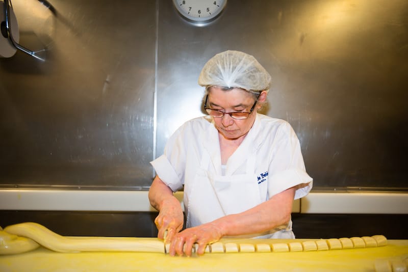An employee shapes laminated pastry into cups, Pastéis de Belém, photo by Austin Bush