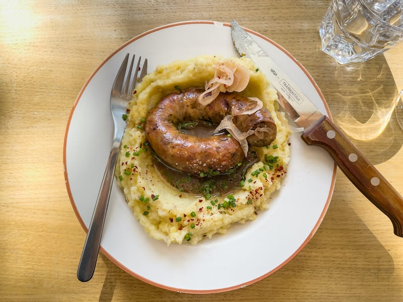 Homemade sausage with potato puree and sauce at Bouillon restaurant and wine shop, photo by Annie Etheridge