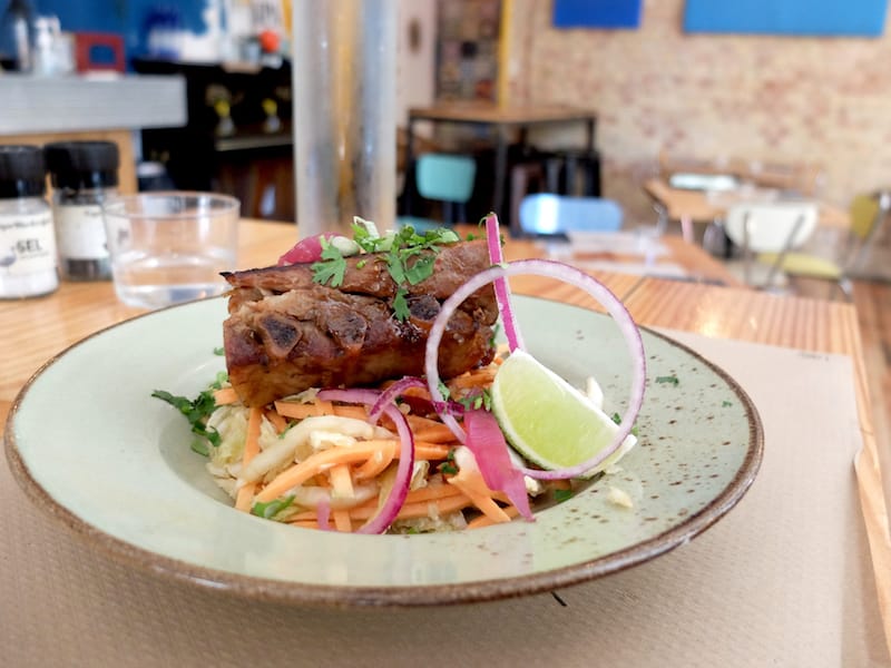 Ribs confit glazed with a soy caramel atop Chinese coleslaw flecked with peanuts, ginger and coriander, photo by Alexis Steinman