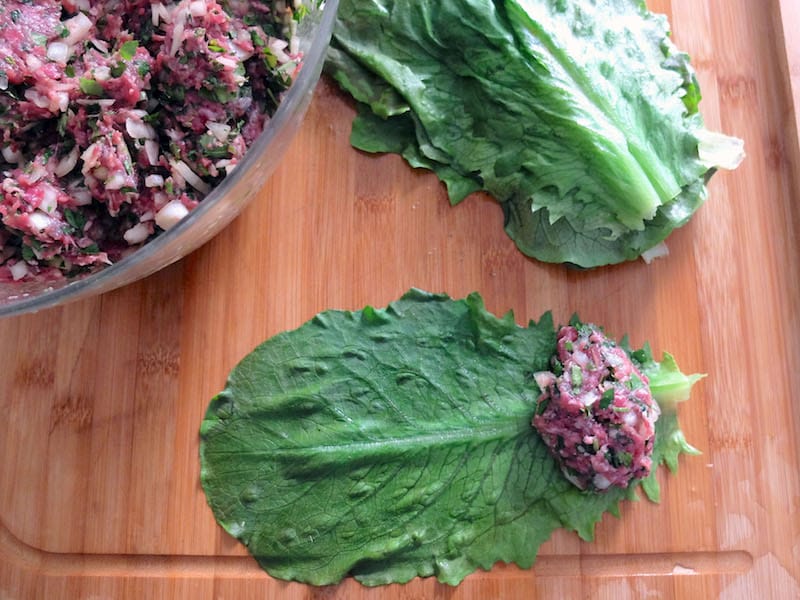 To make the yabrak, place an oval-shaped meatball at the base of each romaine leaf and then roll up the leaf, folding sides towards the meatball as you go to create little packets, photo by Alexis Steinman