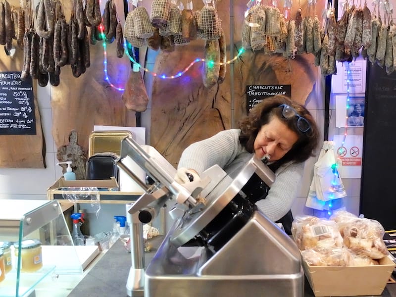 Marie-Paule, the owner of U Mio Paese, slices pork charcuterie, photo by Alexis Steinman