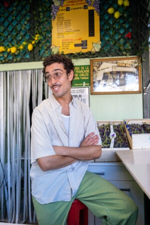 Yannis Amarkaze, owner of Station Uvale du Palais serves fresh pressed juice made from Cardinal grapes at his kiosk, photo by Annie Etheridge