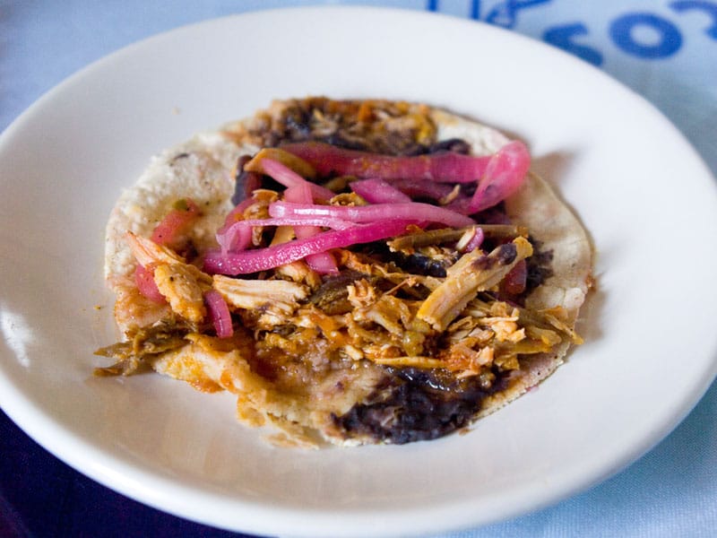 Cochinita pibil taco with black refried beans and pickled onions at Coox Hanal, photo by Ben Herrera