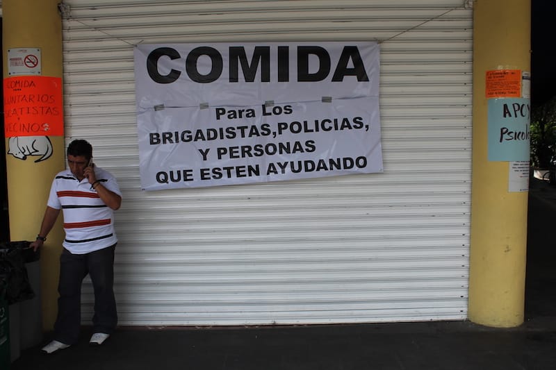 A sign next to Cerveceria del Barrio invites people in to eat, photo by Martha Pskowski