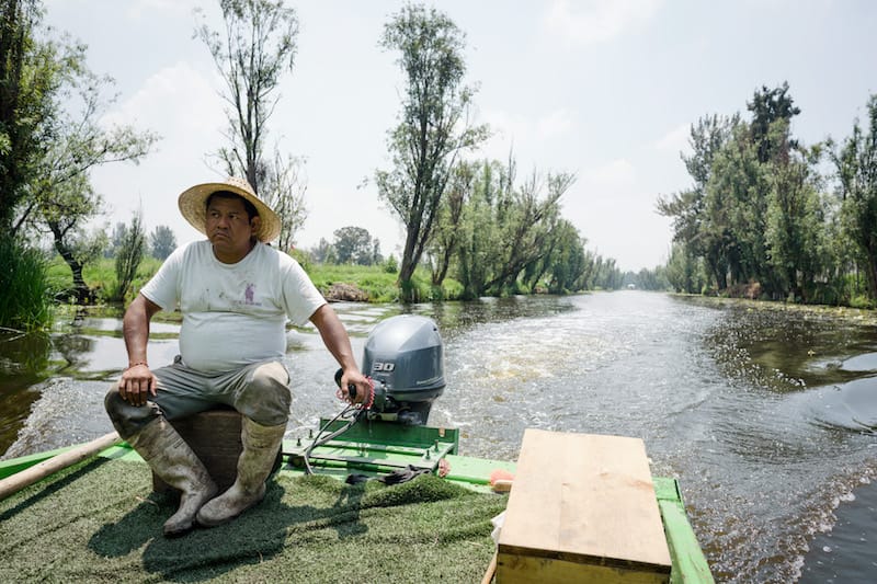 Noé Coquis steering a boat down the canals at Xochimilco, photo by PJ Rountree