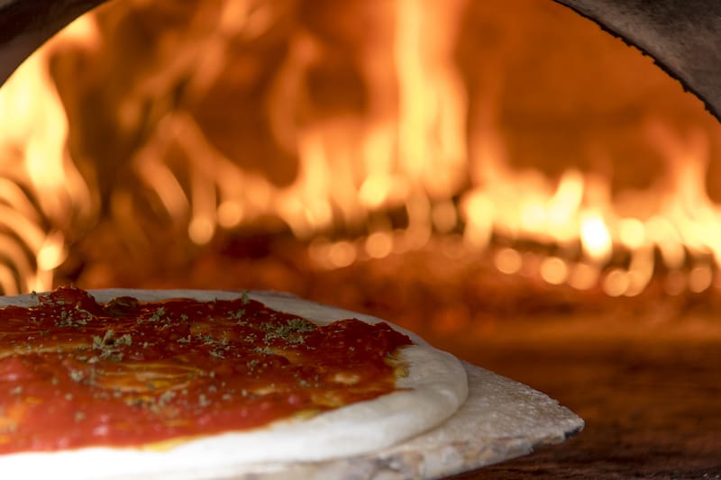 Pizza cilentana, a Cilento-style pie, goes into the oven at Villa Marchesa, photo by Marco Ciullo pizza cilentana