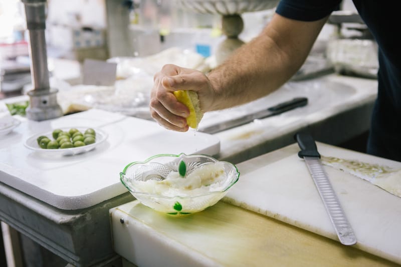 Vincenzo Apicella squeezes a lemon on some rehydrated stockfish, photo by Gianni Cipriano and Sara Smarrazzo