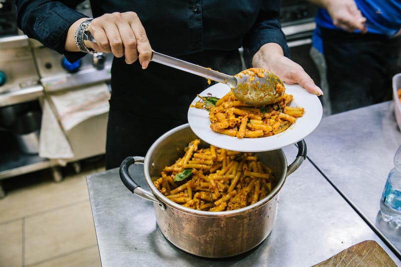 Giusy Aiese spoons pasta into a dish at La Taverna del Buongustaio, photo by Gianni Cipriano and Sara Smarrazzo