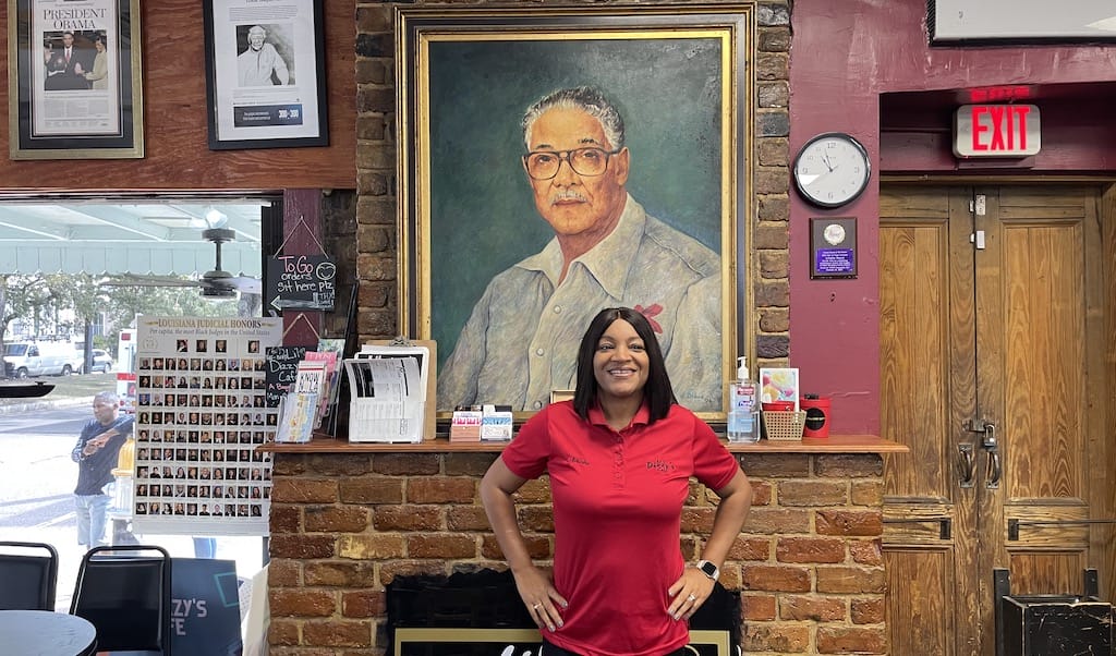 woman stands in front of painting of man