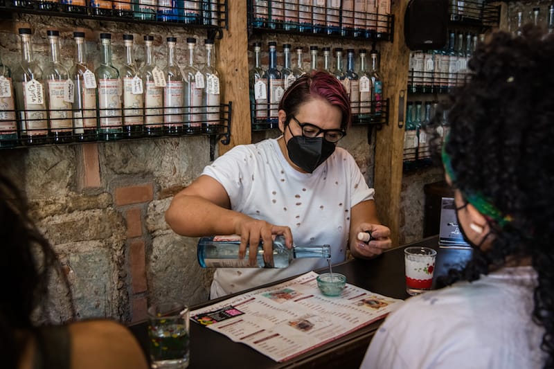 Sandra Ortiz Brena serves customers at In Situ, the mezcaleria she co-founded with Ulises Torrentera in Oaxaca, photo by Jalil Olmedo mezcalerias oaxaca