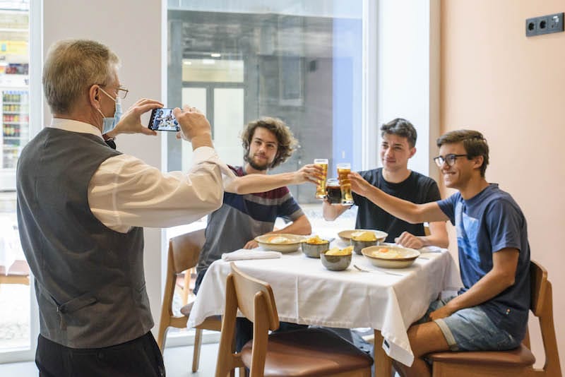 Diners snacking on the francesinha make a toast, photo by Ricardo Castelo