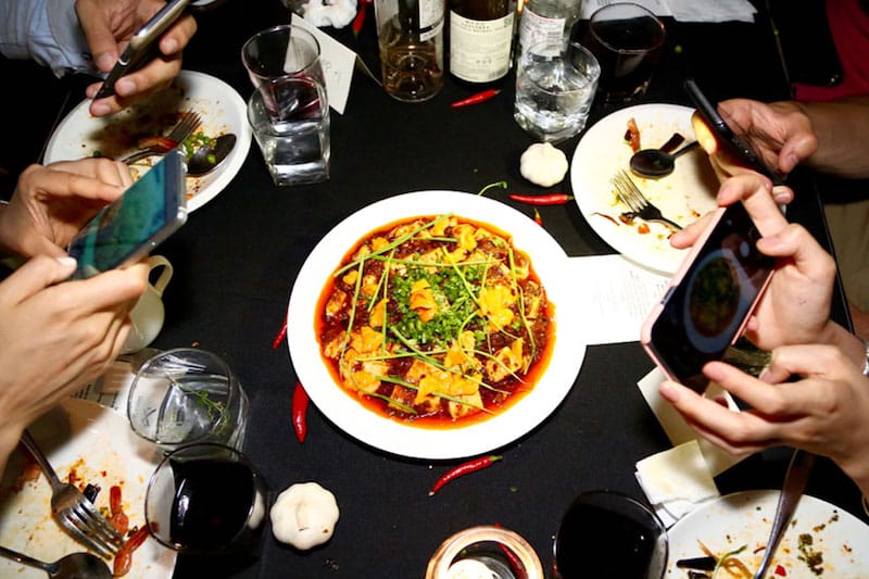 Customers take photos of their food on their smartphones at Fly By Jing, photo courtesy of Fly By Jing