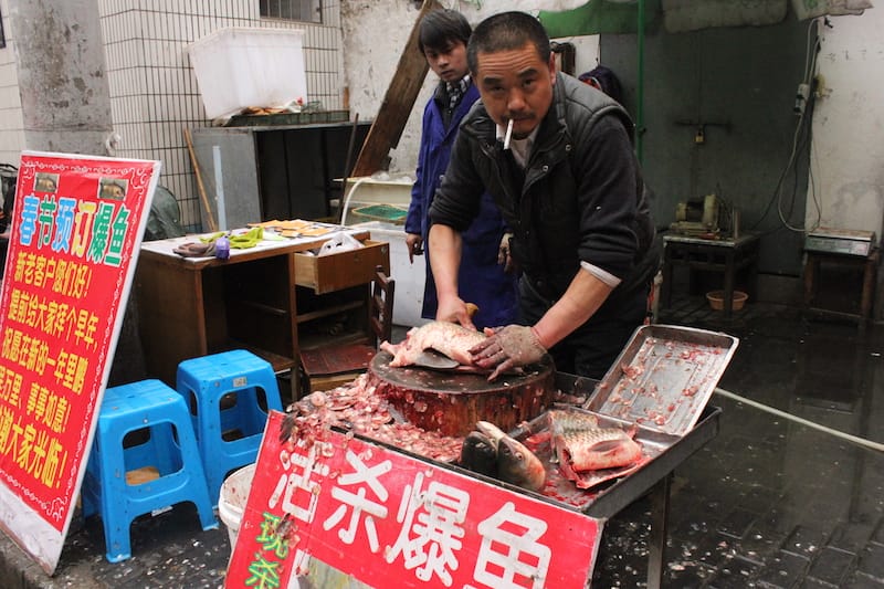 A sidewalk vendor chops fish in Shanghai, photo by Jamie Barys and Kyle Long