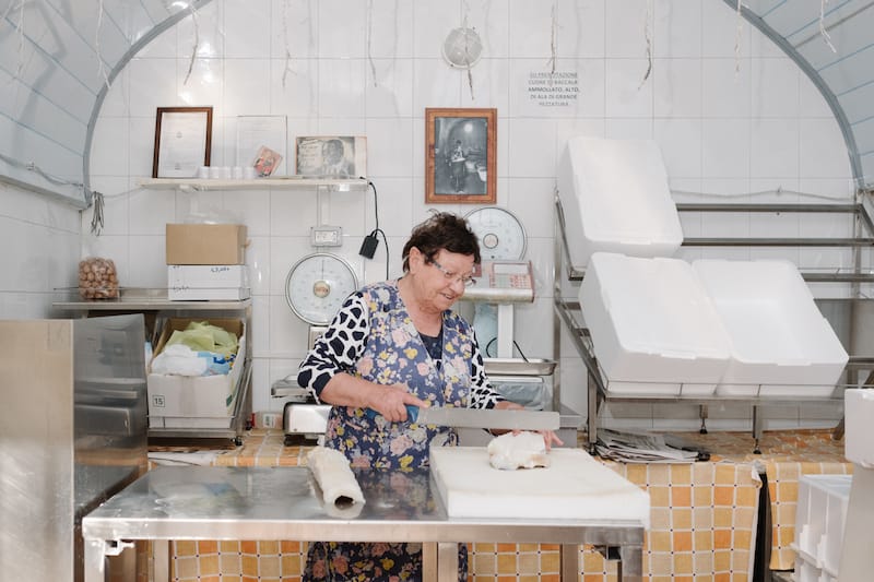 Raffaella Nocerino, known locally as Rafelina “la baccalaiola,” prepares aged cod in her small baccaleria, photo by Carlo Rainone