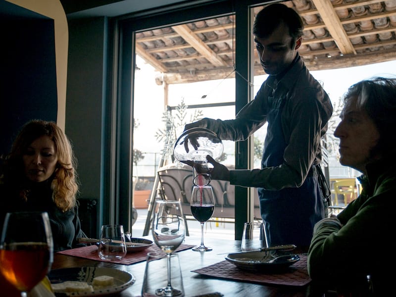 Waiter pouring saperavi from a carafe, photo by Justyna Mielnikiewicz