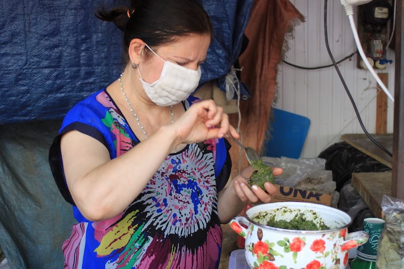 A vendor packs freshly made green adjika paste into a container, photo by Paul Rimple