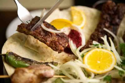 Juicy lamb kebabs served with sumac, charbroiled tomatoes and green chillies are the restaurant's main draw, photo by Pearly Jacob