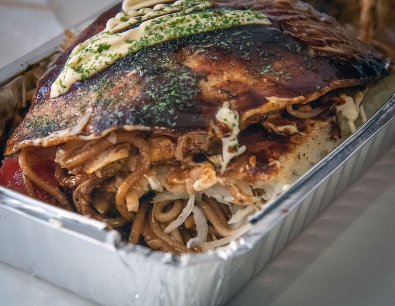 Okonomiyaki, a pancake stuffed with noodles, pork/chicken, cabbage and smothered in a homemade okonomiyaki sauce, is a favorite at Piccolo Cafe in Tbilisi, photo by Justyna Mielnikiewicz