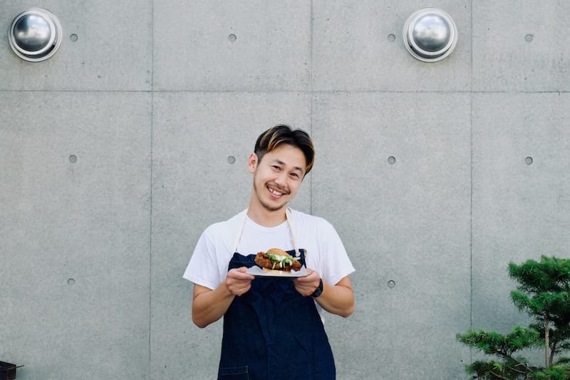 Chan holding a plate of his signature chicken schnitzel sandwich, photo by Florentyna Leow